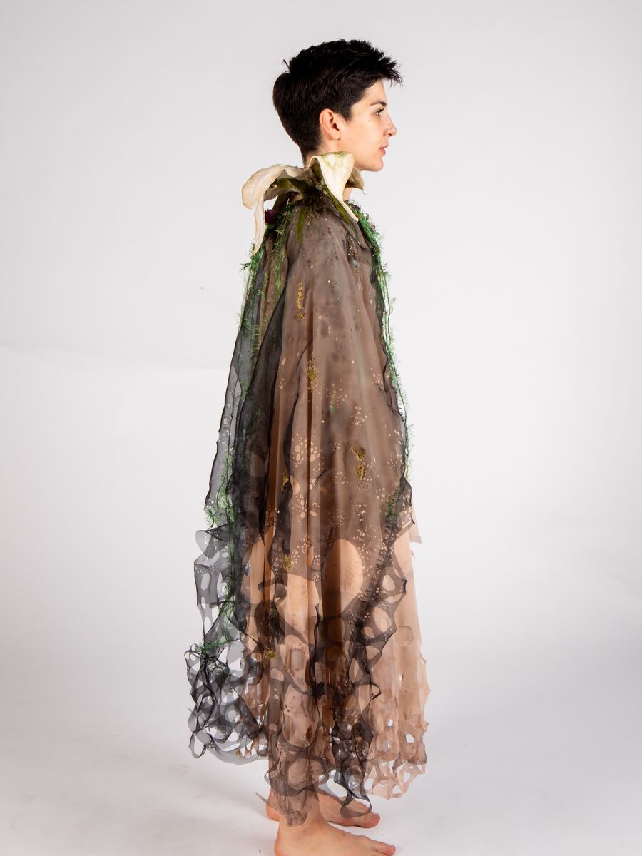Sheer draped costume with organic surface detailing, shown full length